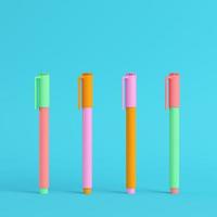 Four colorful marker pens on bright blue background in pastel colors. Minimalism concept photo