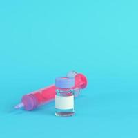 jeringa rosa con vacuna sobre fondo azul brillante en colores pastel