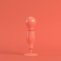 Lamp with light bulb in living coral color. Minimalism concept photo