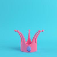 Pink cartoon-styled crown with blue gem on bright blue background in pastel colors