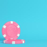 Pink casino chips on bright blue background in pastel colors photo