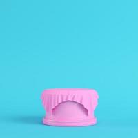 Pink pedestal covered by fabric on bright blue background in pastel colors photo