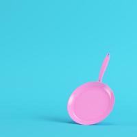 Pink frying pan on bright blue background in pastel colors photo