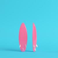 Pink surfboard on bright blue background in pastel colors. Minimalism concept photo