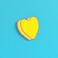 Yellow abstract heart shape on bright blue background in pastel colors photo