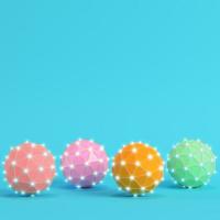 Four colorful low poly abstract glowing spheres on bright blue background in pastel colors photo