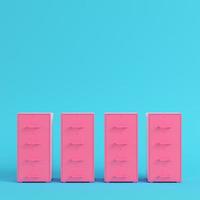 Pink filing cabinets on bright blue background in pastel colors. Minimalism concept photo