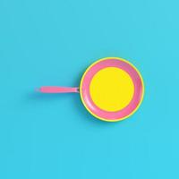 Yellow frying pan on bright blue background in pastel colors photo