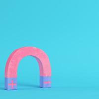 Pink magnet on bright blue background in pastel colors photo