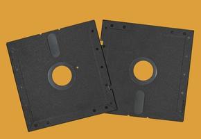 Vintage Floppy Disk 5.25 inch. Retro storage technology isolated on orange background. photo