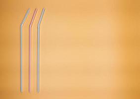 Colorful drinking straws isolated on orange background. photo