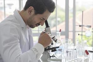 Young scientist medical worker in lab , doing a microscope analysis in a laboratory doing research photo