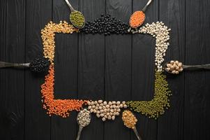 Legumes, overhead flat lay shot on a dark rustic wooden background with a place for text photo