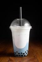 Milky bubble tea with tapioca pearls in plastic cup photo