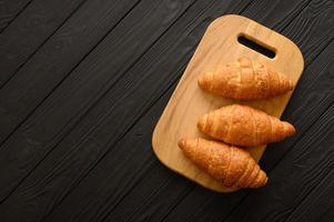 croissants recién hechos sobre un fondo de madera. foto