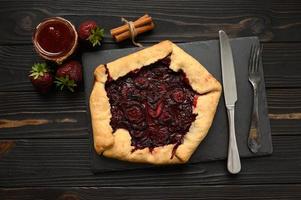 galette de fresa sobre fondo de madera oscura. hecho en casa foto