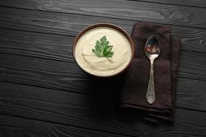 Cream of cauliflower soup on a dark wooden background. photo