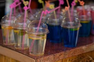 diferentes colores de agua fría en un vaso de plástico. foto