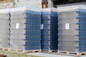 Empty beer bottles in packs stand on the territory of the brewery. photo