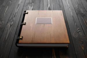 An old photo album with a wooden cover and a shield on a rustic table. free logo