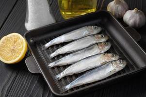 Fresh sardines on rustic wooden background. photo