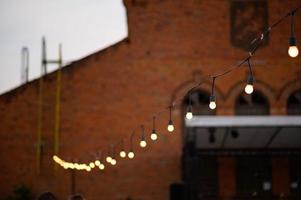 Garlands of lamps on a wooden stand on the street. A wedding Banquet. photo