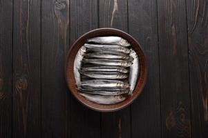 Fresh sardines on rustic wooden background. photo