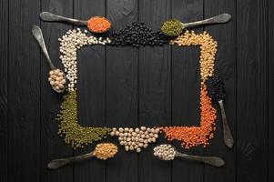 Legumes, overhead flat lay shot on a dark rustic wooden background with a place for text photo