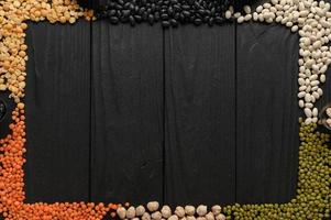 Legumes, overhead flat lay shot on a dark rustic wooden background with a place for text photo