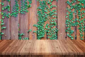 Empty wooden table with wood and vine wall background photo