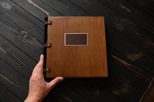 An old photo album with a wooden cover and a shield on a rustic table. free logo