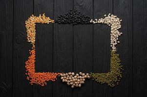 Legumes, overhead flat lay shot on a dark rustic wooden background with a place for text photo