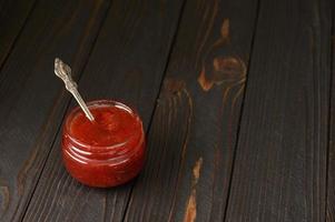 Homemade cherry jam on a rustic background photo