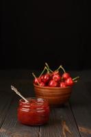 Homemade cherry jam on a rustic background photo