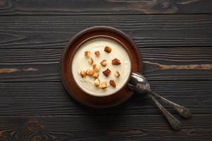 Cream of cauliflower soup on a dark wooden background. photo