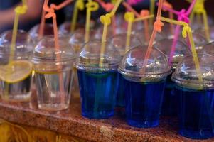 Different colors of cold water in a plastic cup. photo