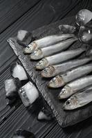 Fresh sardines on rustic wooden background. photo