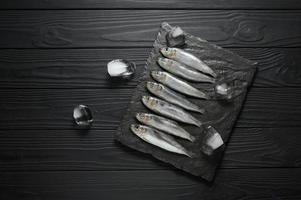 Fresh sardines on rustic wooden background. photo