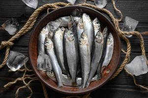 Fresh sardines on rustic wooden background. photo