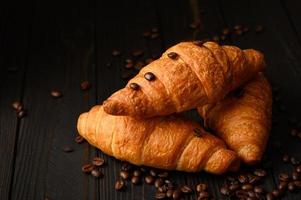 Fresh croissants on a wooden background. photo