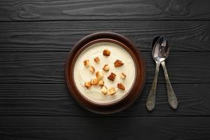 Cream of cauliflower soup on a dark wooden background. photo