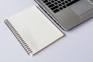 Notebook with computer on white table photo