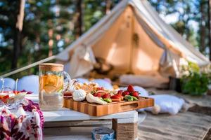 picnic en la naturaleza, mesa, alfombras, wigwam, carpa, almohadas en el parque. foto