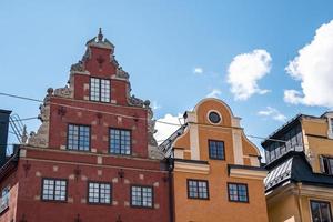 Low angle facade of colorful buildings in old town square against blue sky photo