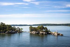 View of lighthouse on rocks in island of Archipelago amidst blue Baltic Sea photo