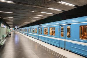 Passengers traveling in blue train arrived at subway of Stadion station in city photo