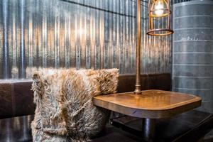 Fur cushion by illuminated table with sofa in Espresso House at famous city photo