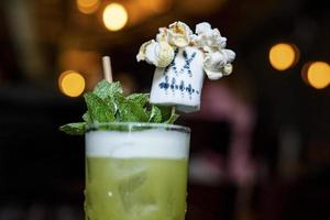 Close-up of frothy cocktail with marshmallow topper in glass at restaurant photo