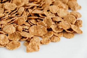 Crispy healthy dry cereal flakes on white background photo