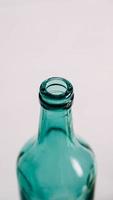 Glass transparent green bottle for liquids without the cap on a white background photo